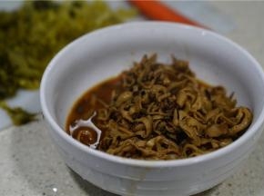炒至微微入味之后，再盛在碗里，将酸菜洗切好。