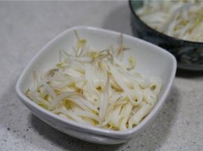 然后将煮好的豆芽面条控水之后入碗里。