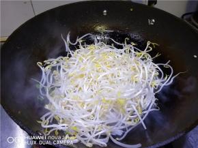 锅中倒入适量油烧热，倒入准备好的豆芽大火炒。