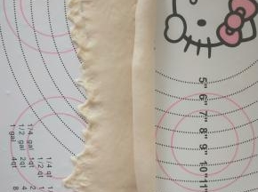 取一个面团擀开成椭圆形，从上卷起。收紧封口。