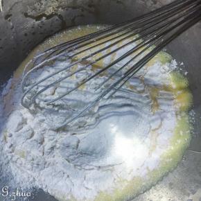 4过筛低粉至蛋黄糊中，左右上下的搅拌，搅拌好的蛋黄糊呈丝带状。