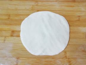 给案板上抹一些油，将饧发好的面团取出放在案板上压扁。