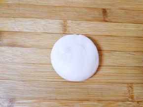 将小面团立在案板上压扁。