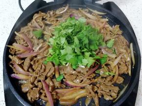 下入香菜，这时候牛肉已经熟了，电饼铛也停了，利用电饼铛的余热把牛肉和香菜翻炒均匀。