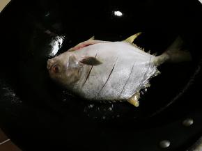 热锅热油放入金昌鱼中火煎金黄