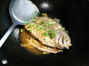 中火烧至汤汁还剩三分之一，中途翻面，用勺子浇汤汁金昌鱼表面，撒入青蒜，青蒜经过热气一熏，味道特别好