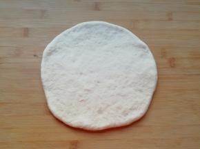 发酵好的面团揉光排气，擀成一张比模具大一些的面饼。