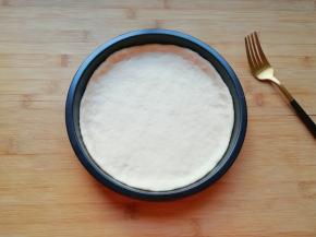 放进披萨盘里，用手把大出来的部分压实，使其贴在披萨盘的边上。