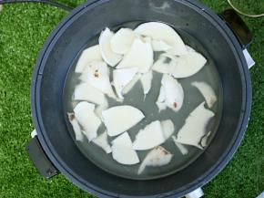 椰青钻孔，倒出椰汁，同时把椰肉挖出来，放入九阳玉京火锅中，再加入适量清水。