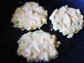 热锅里倒入适量的花生油，烧至六成热时，用勺子挖一勺面糊放入锅中摊圆，用小火慢慢煎制。