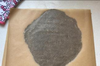 将饼底面团置于一张油纸上，表面覆盖另一张油纸，擀成厚度在1厘米的薄片