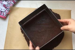 用慕斯圈压出需要的大小后，将饼底转移至已包裹好锡纸的慕斯圈中。多余的饼底材料，切勿丢掉，用保鲜膜包裹，后面还要用它装饰蛋糕表面