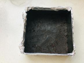 奥利奥碎加入融化的黄油，搅拌均匀后，放入到包裹好锡纸的慕斯圈中，压实。放入冰箱冷藏定型