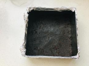 奥利奥碎加入融化的黄油，搅拌均匀后，放入到包裹好锡纸的慕斯圈中，压实。放入冰箱冷藏定型