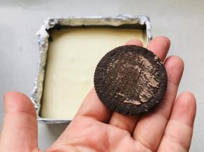 再将剩余的芝士糊全部倒入到模具中，奥利奥饼干刮掉夹心