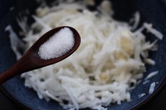 擦好的萝卜丝里加入适量的盐，搅拌均匀后腌制一会。