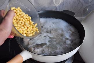 加入泡好的黄豆，大火煮开后，转小火慢炖。如果时间充裕，您就让它慢慢炖，如果您没有时间，那就把它们倒进压力锅煮制，都可以。