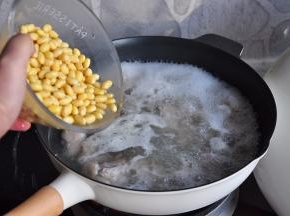 加入泡好的黄豆，大火煮开后，转小火慢炖。如果时间充裕，您就让它慢慢炖，如果您没有时间，那就把它们倒进压力锅煮制，都可以。