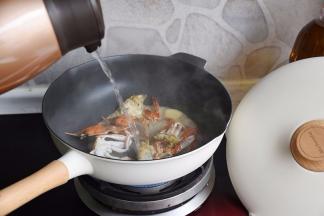 蟹身煎制时会慢慢变红，这时加入热水。一定要加热水，请大家注意，这时会使蟹身体的蛋白质快速凝固，保持最鲜美的状态。