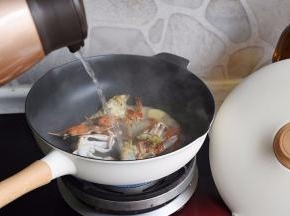 蟹身煎制时会慢慢变红，这时加入热水。一定要加热水，请大家注意，这时会使蟹身体的蛋白质快速凝固，保持最鲜美的状态。