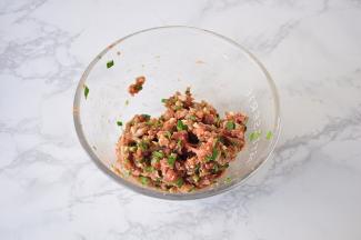 先将肉馅加入酱油、料酒搅匀上劲后略腌制，然后加入盐、芝麻油、韭菜末拌匀备用。韭菜不必多，五六根调个味即可，太多了会抢味。