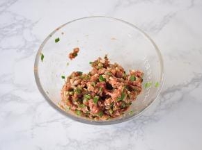 先将肉馅加入酱油、料酒搅匀上劲后略腌制，然后加入盐、芝麻油、韭菜末拌匀备用。韭菜不必多，五六根调个味即可，太多了会抢味。