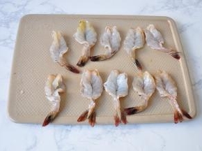 用刀将虾的虾背剖开，尾部不要动。这样还可以顺便去除虾线。