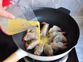 待锅中的水基本收尽，将提前打散的蛋液均匀的倒入锅中。