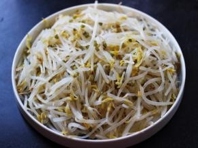 把焯过水的绿豆芽捞出沥干水分后、放入一个深一点的盘子里。