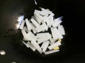 放入白萝卜条翻炒片刻