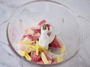 把猪肉放入料理机中，加入姜丝、蒜片，打成肉末