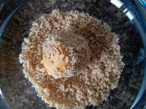 包好豆沙的南瓜球放进芝麻碗内，沾上芝麻