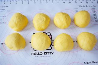 取出面团排气后，平均分成8份，滚团盖保鲜膜松弛20分钟