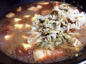 大火烧开后转中火，肉炖熟、汤水剩余约一半时放入土豆块和酸菜丝