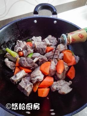 放入一汤匙料酒，放入适量的生抽、老抽，翻炒至羊肉上色