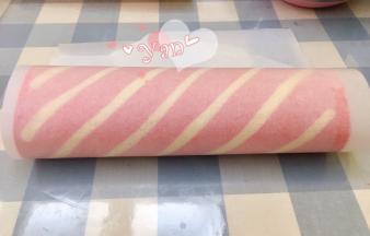 用擀面杖卷住油纸，顺势往上推。卷起来，两边跟拧糖一样拧起来。放入冰箱冷藏半小时后再切块食用。