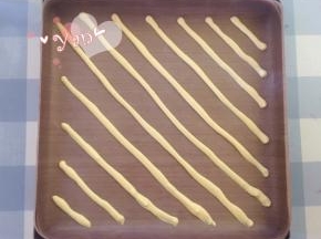 28*28烤盘铺油布，裱花袋剪个小口，挤入斜条纹图案。放入烤箱，165度烤2分钟定型。