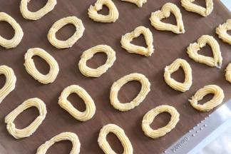 烤盘上放上油布，这个饼干的制作最好垫油布。方便取下。没有油布的话，不粘烤盘晾凉也是可以取下的。挤出圆形的圈圈，首尾一定要接好，不要断，会漏糖心的。挤的粗细可以按照自己喜好来。