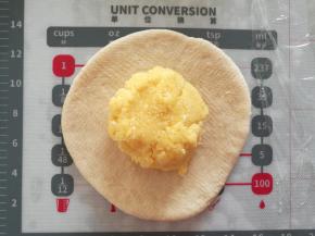 取其中一份，将馅料的1/6，放在面团中收口。