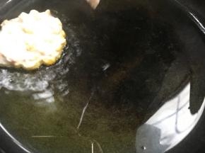 用勺子把玉米糊舀入锅中，大小随意