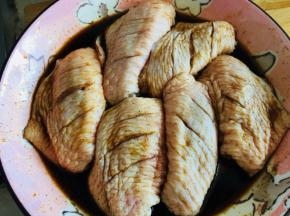 鸡翅裹满调料腌制，盖保鲜膜放冰箱冷藏三个小时以上
