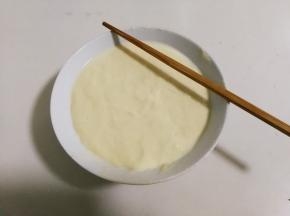 将碗中面团表面沾满水，筷子也沾上水