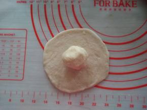 醒发后的小面团擀圆，中间厚四周薄，放上馅料