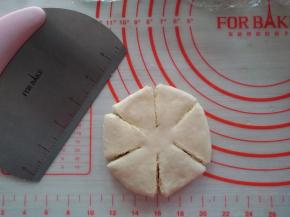 用手掌压扁，用切面刀切成6瓣，中间不切断