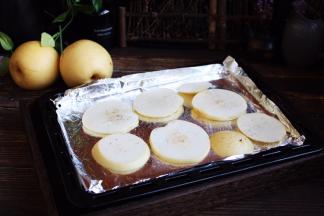 将梨片平铺在烤盘上。