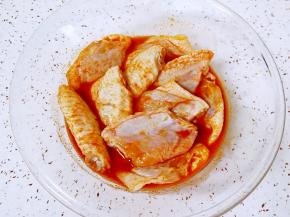 放入鸡中翅，带上一次性手套抓捏均匀，盖上保鲜膜腌制4个小时以上，中间再抓捏几次。