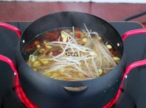 豆芽洗净，去根本，放入熬好的麻辣高汤锅里。其中豆芽选择黄豆芽会比较好吃。