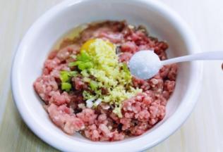 将切好的葱姜蒜末加入肉糜中，加入盐。