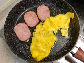鸡蛋煎熟，火腿煎制片刻。