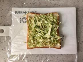 吐司片下垫一张保鲜膜，铺上一半的卷心菜。